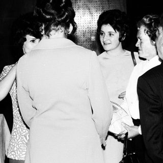 Group of people conversing in a dimly lit room.