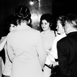 Group of people conversing in a dimly lit room.
