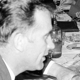 Group seated at a table, server approaches with plates.