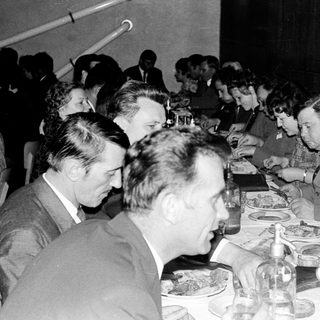 Group seated at a table, server approaches with plates.