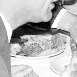 Group seated at a table, server approaches with plates.