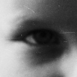 Black and white portrait of a young boy looking forward.
