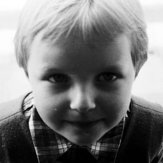 Black and white portrait of a young boy looking forward.