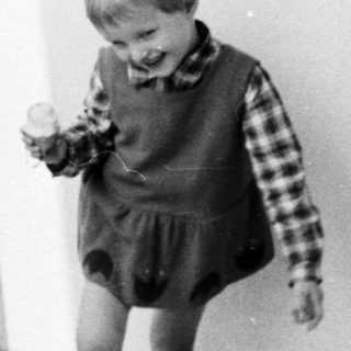 Black and white photo of a young boy on a balcony.