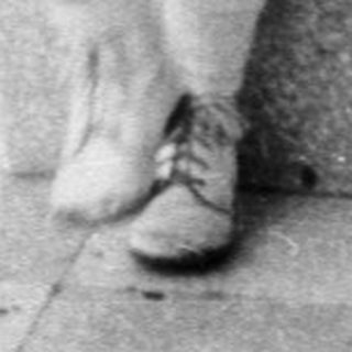 Black and white photo of a young boy on a balcony.