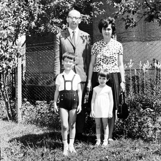 Family portrait, 1960s, standing in front of a house.