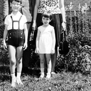 Family portrait, 1960s, standing in front of a house.