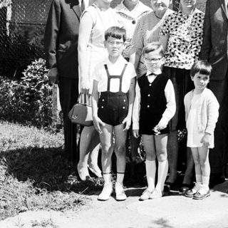 Black and white family portrait in front of a house.