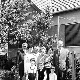 Black and white family portrait in front of a house.
