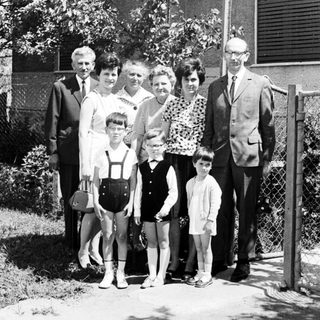 Black and white family portrait in front of a house.