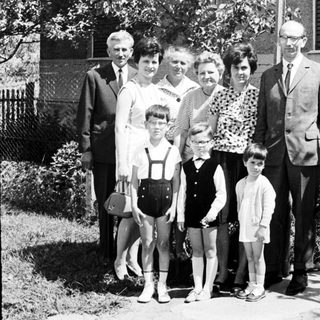 Black and white family portrait in front of a house.
