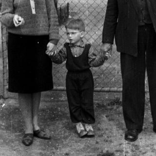 Black and white photo of a family standing outside.