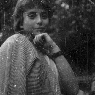 Here's a brief summary of the image: Black and white portrait of a person with a textured sweater.