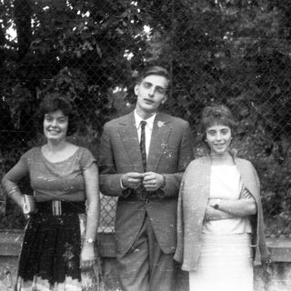 Black and white photo of three people standing outdoors.