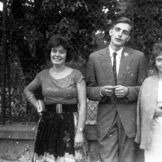 Black and white photo of three people standing outdoors.