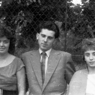 Black and white photo of three people posing outdoors.