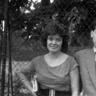 Black and white photo of three people posing outdoors.