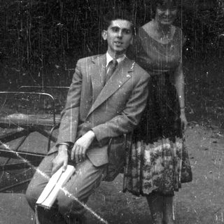 Man and woman seated on a bench, black and white.