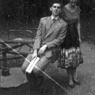 Man and woman seated on a bench, black and white.
