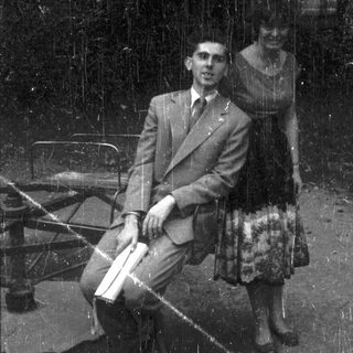 Man and woman seated on a bench, black and white.