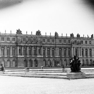 Black and white image of a grand palace and garden.