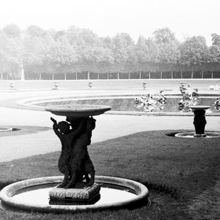 Black and white photo of a formal garden with statues.