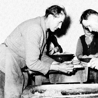 Men working at a mill, likely processing grain.