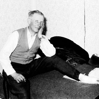 Man with injured leg, seated in a room.