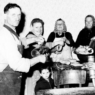 Family making cheese in a vintage, rural setting.