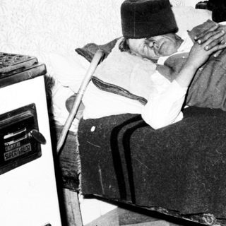 Injured man lies in bed, supported by a pillow.