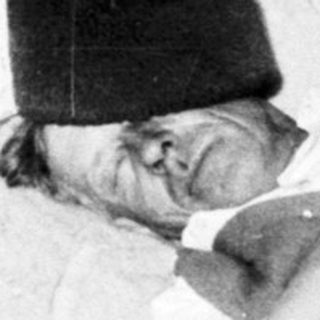 Injured man lies in bed, supported by a pillow.