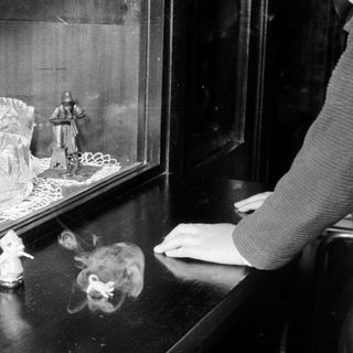 Vintage figurines displayed in a glass case.