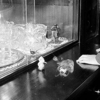 Vintage figurines displayed in a glass case.