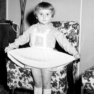 Black and white photo of a young girl in a dress.