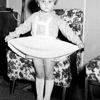 Black and white photo of a young girl in a dress.