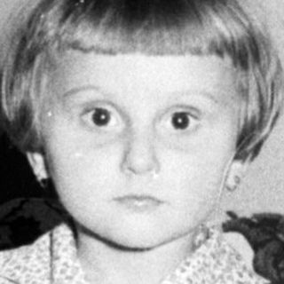 Black and white photo of a young girl in a dress.