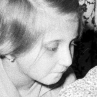 Two children blow out candles on a cake.
