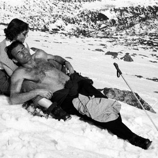 Injured man lies in snow, woman kneels nearby.