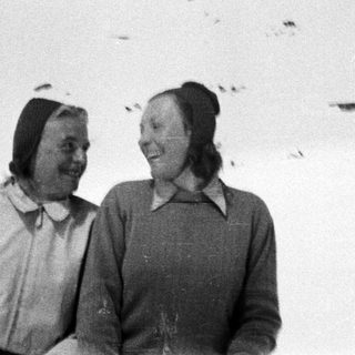 Two people smile in a snowy, outdoor setting.