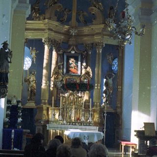 Elaborate altar with statues inside a church interior.