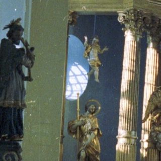 Elaborate altar with statues inside a church interior.