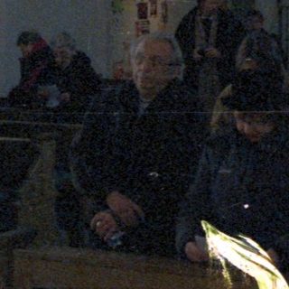 People inside a dimly lit, ornate church interior.