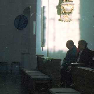 People seated in a dimly lit, ornate interior space.