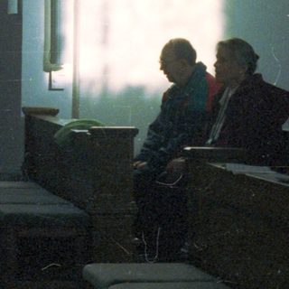 People seated in a dimly lit, ornate interior space.