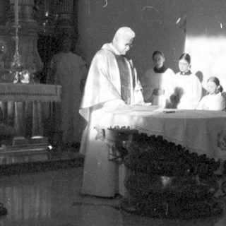 Here's a brief summary of the image: Priests performing a ceremony in a church setting.