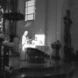 Here's a brief summary of the image: Religious ceremony taking place in a church setting.
