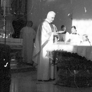 Here's a brief summary of the image: Religious ceremony taking place in a church setting.