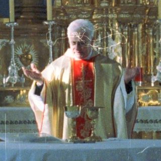 Here's a brief summary of the image: Priest officiating at an altar with attendants in a church.
