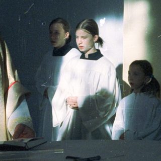 Priest and altar servers during a religious ceremony.