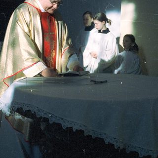 Priest and altar servers at a religious ceremony.